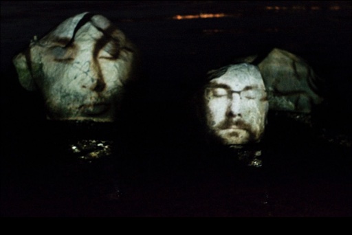 Elementals installation with projected faces on rocks